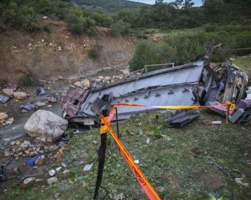 巴士墜崖，車頭全毀、遺體散布河床。AP
