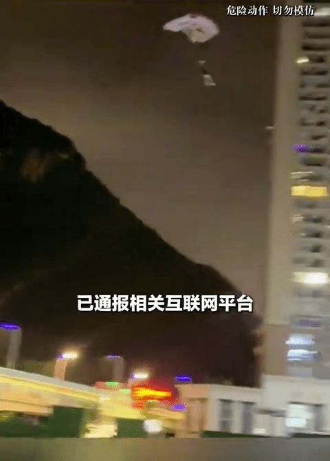 男子深夜貼近樓宇樹叢跳傘。