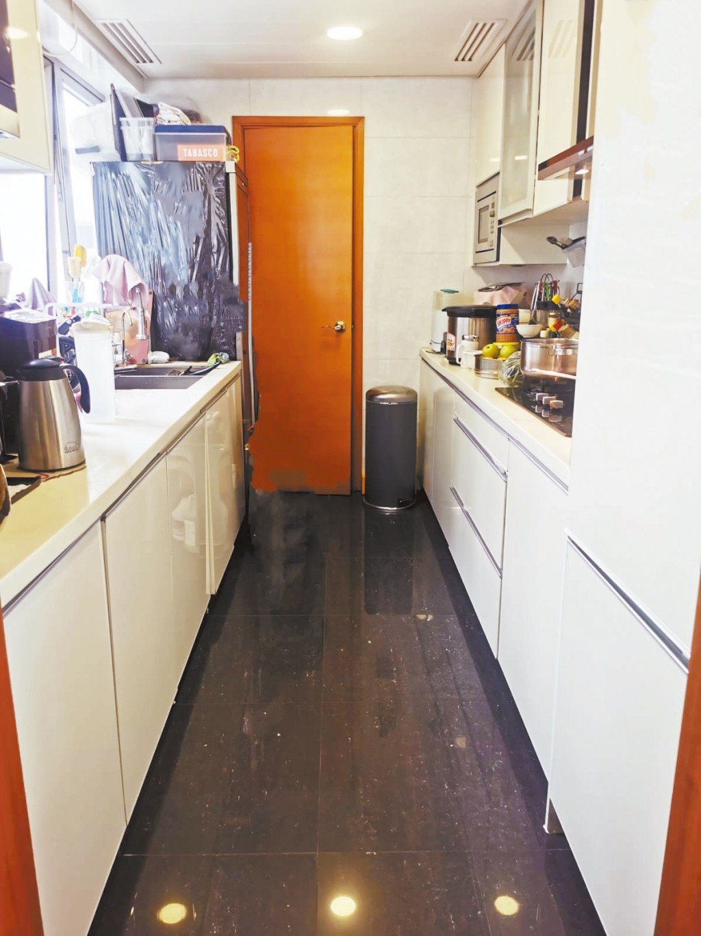 長形廚房設有雙邊工作枱，基本爐具及家電齊備。