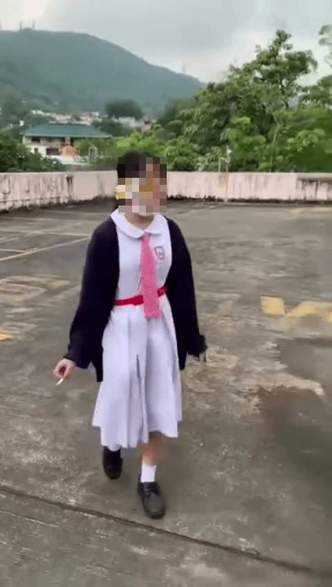 一名身穿校服的中學女生在一處天台「邊行邊食煙」。網圖
