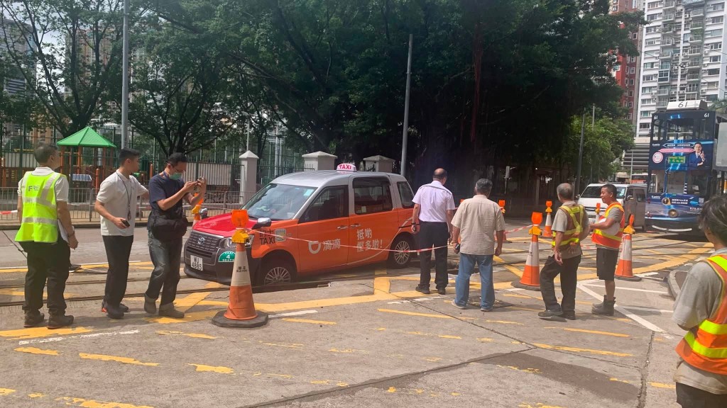 一轉的士衝入維修中的電車路軌，其前轆陷入坑內被困。網上圖片