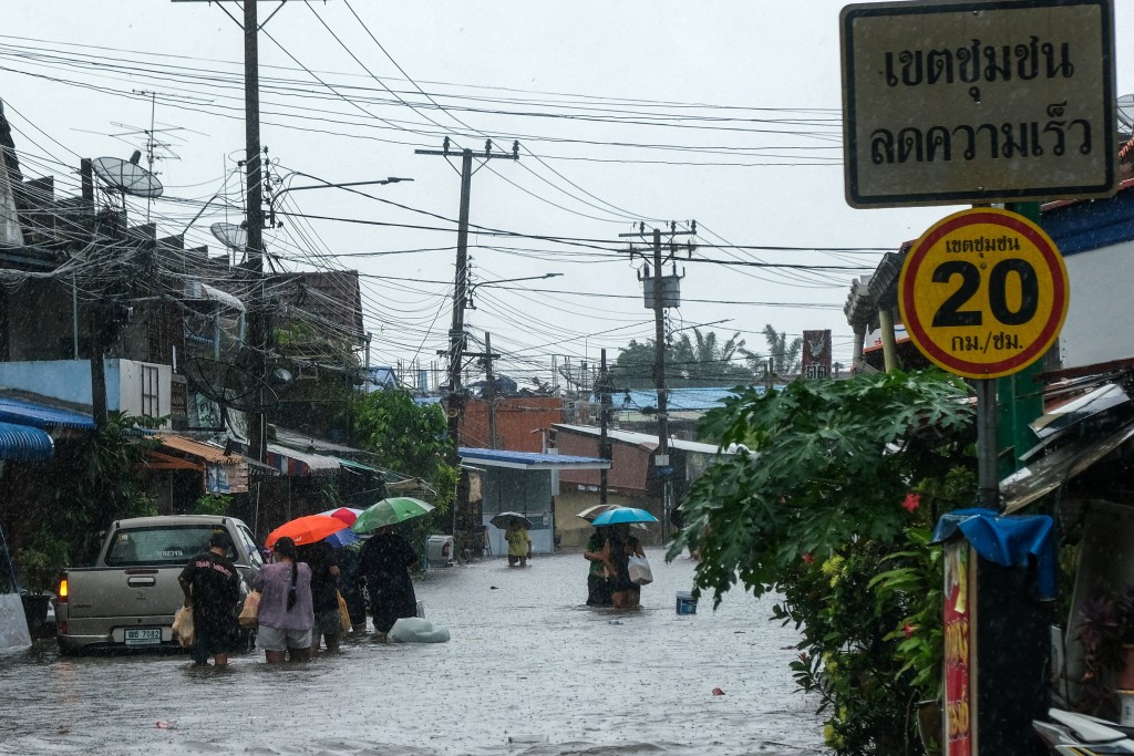 曼谷多条街道被洪水淹没，停泊路旁的汽车几乎被水淹没，居民则要涉过及膝积水。路透社