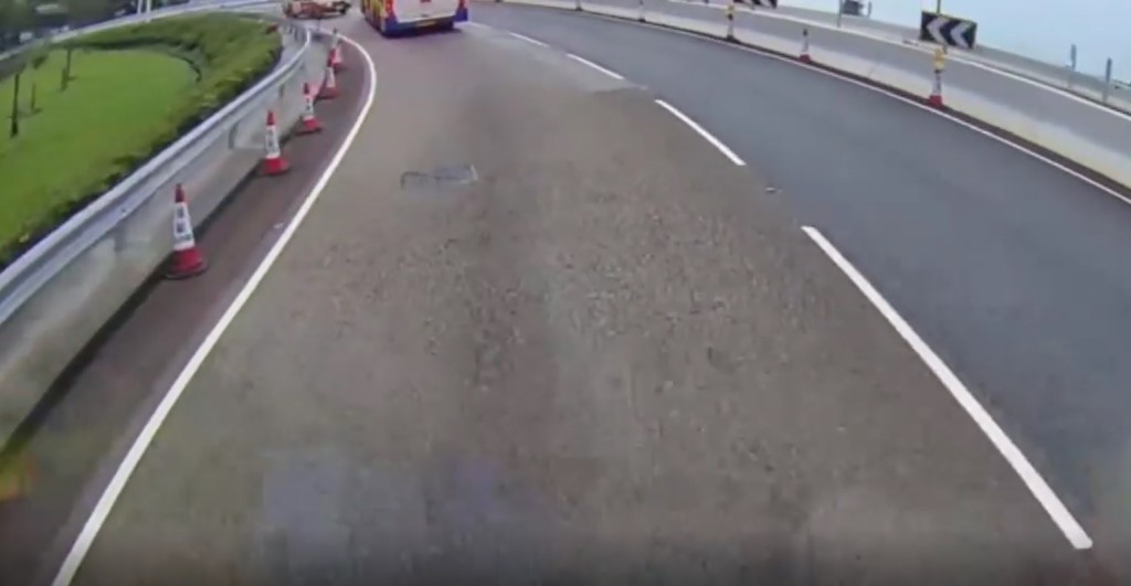一辆的士驶入西隧出口期间，一辆城巴刚巧驶出。(影片截图)