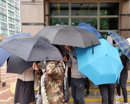 24歲被告鄧力豪被傘陣包圍。 葉君怡攝
