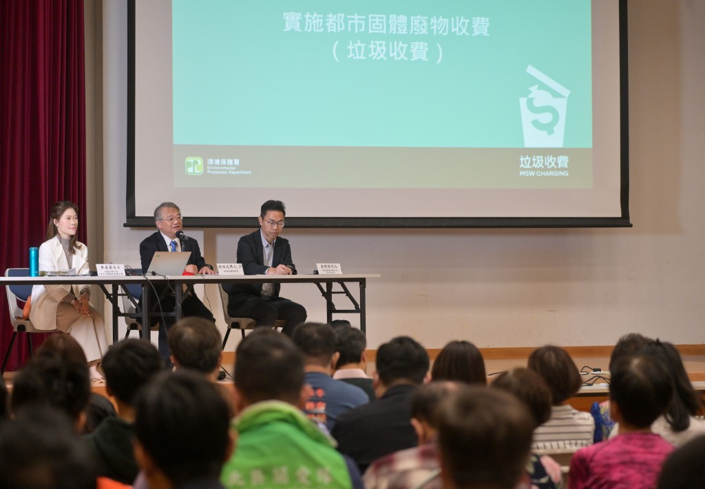 环保署署长徐浩光（中）向关爱队成员讲解垃圾收费的最新推行安排。政府新闻处图片