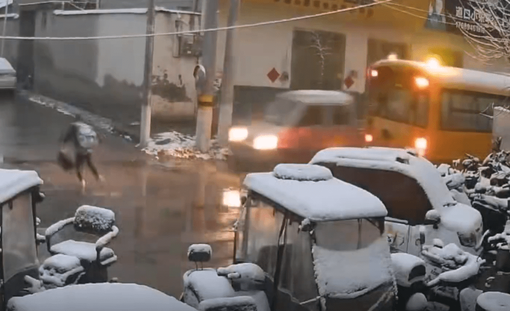 男童過馬路時,一輛小貨車從校車對線駛出。 男童過馬路時,一輛小貨車從校車對線駛出。