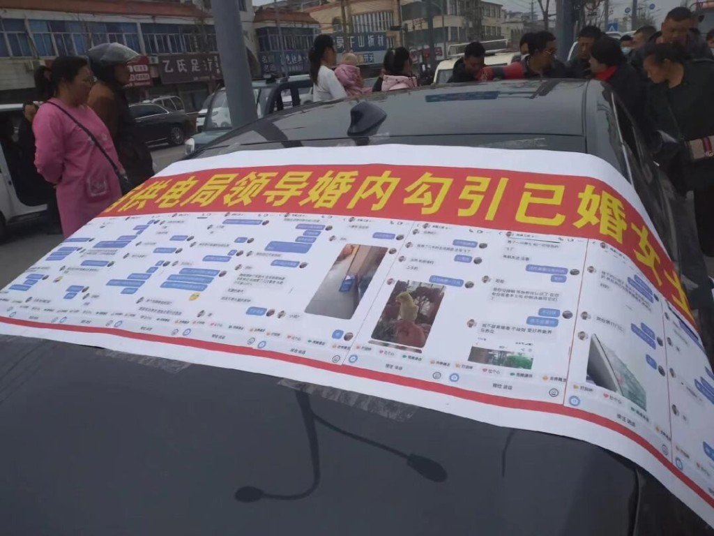  江苏男汽车上被拉聊天记录横幅举报供电局领导婚内勾引人妻。 