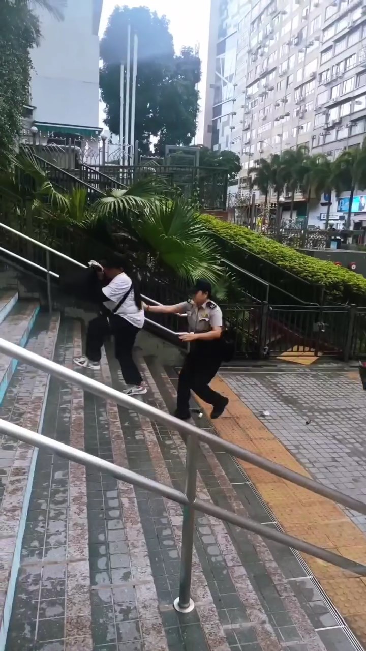 食環署人員於尖沙咀站A出口對開追趕數名非華裔女子。網上片段截圖 食環署人員於尖沙咀站A出口對開追趕數名非華裔女子。網上片段截圖