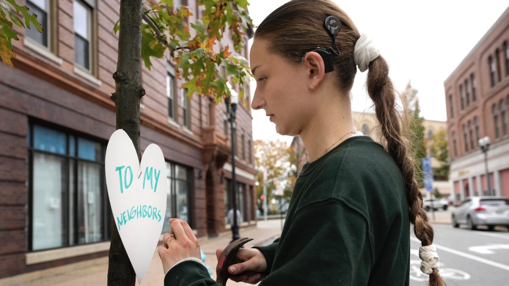 一名美术老师在刘易斯顿市中心街头贴心形纸牌问候邻居。美联社