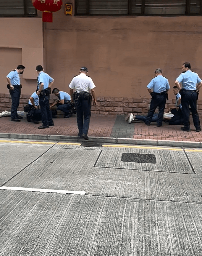 兩名男子扒在地上。fb：車cam L（香港群組）