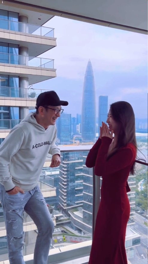 吴启华与一名女士在高楼大厦内的阳台有讲有笑。