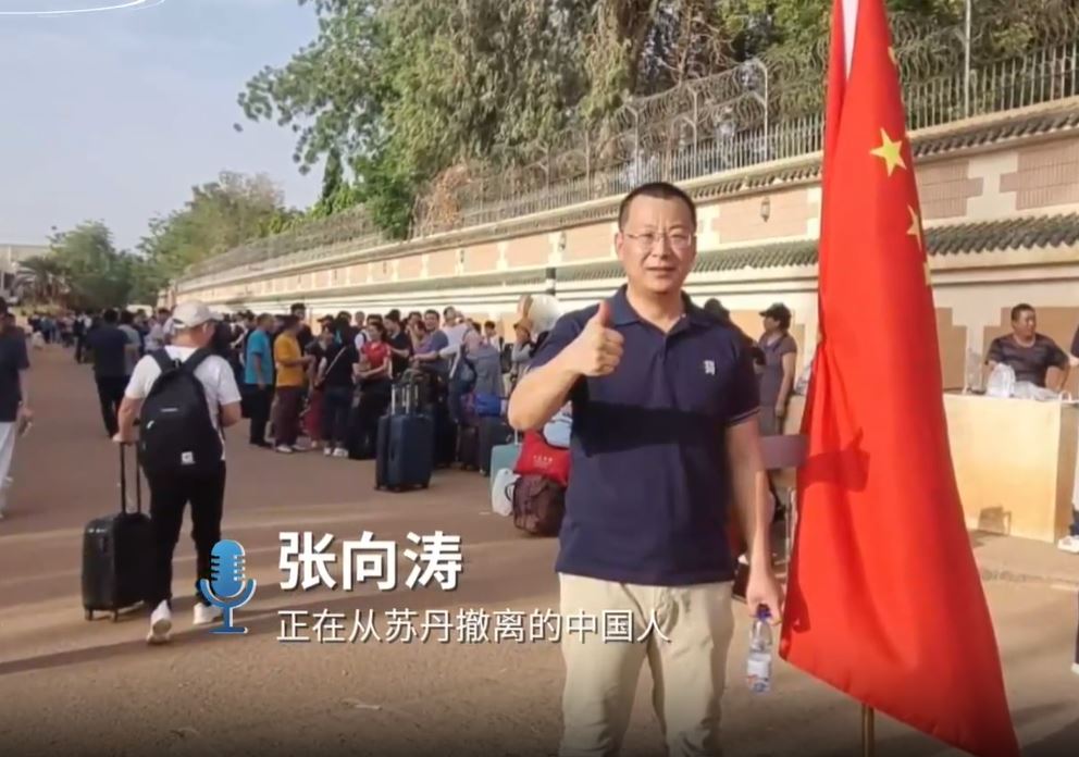 撤离的中国人和国旗合影报平安。