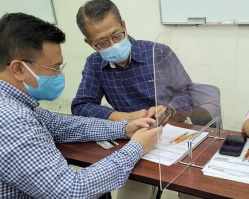 財政司司長陳茂波落區協助市民登記領取電子消費券，指過程非常暢順。FB圖片