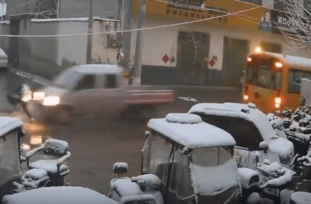 男童過馬路時,一輛小貨車從校車對線駛出,撞向男童。 男童過馬路時,一輛小貨車從校車對線駛出,撞向男童。