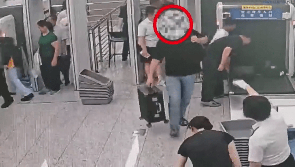 黑衫旅客當即被工作人員截停。 黑衫旅客當即被工作人員截停。