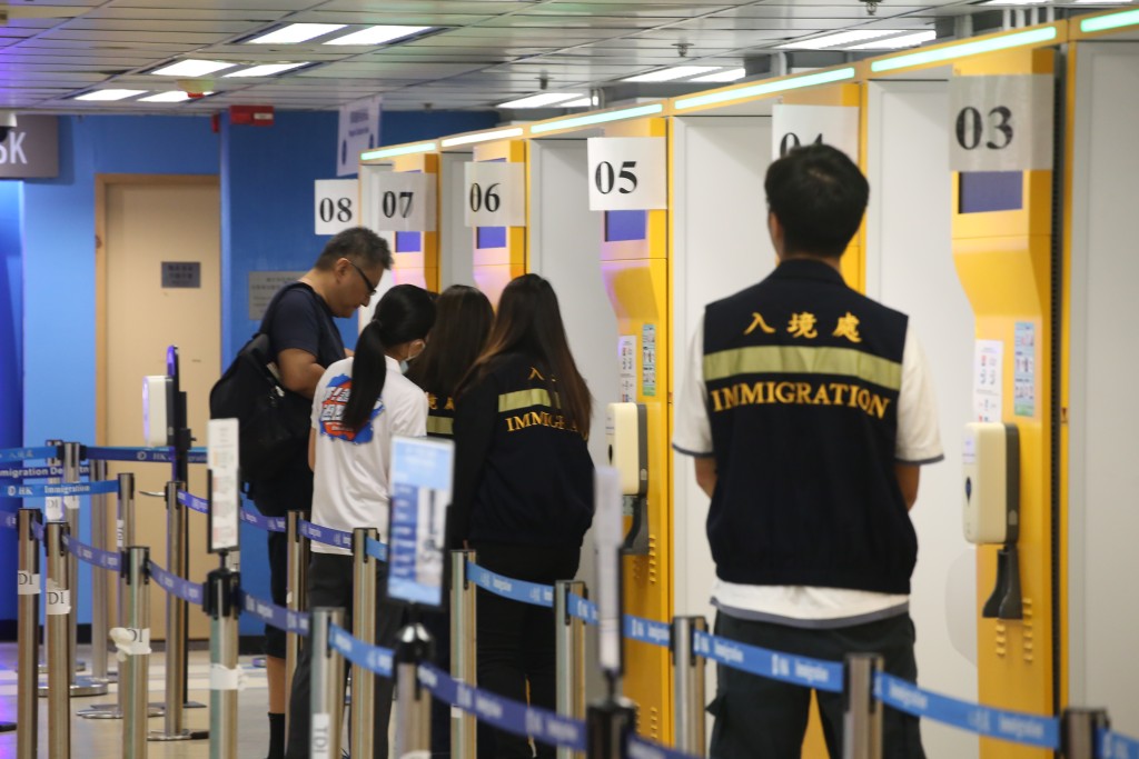入境处职员协助市民领取旅游证件。