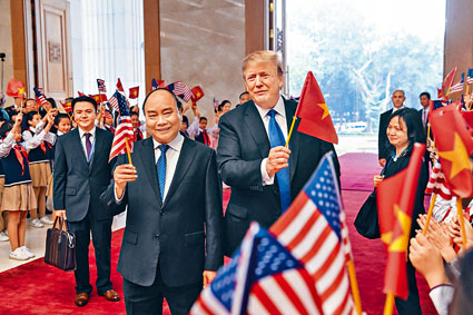 特朗普與越南總理阮春福會面後，手持對方國家的旗幟拍照。