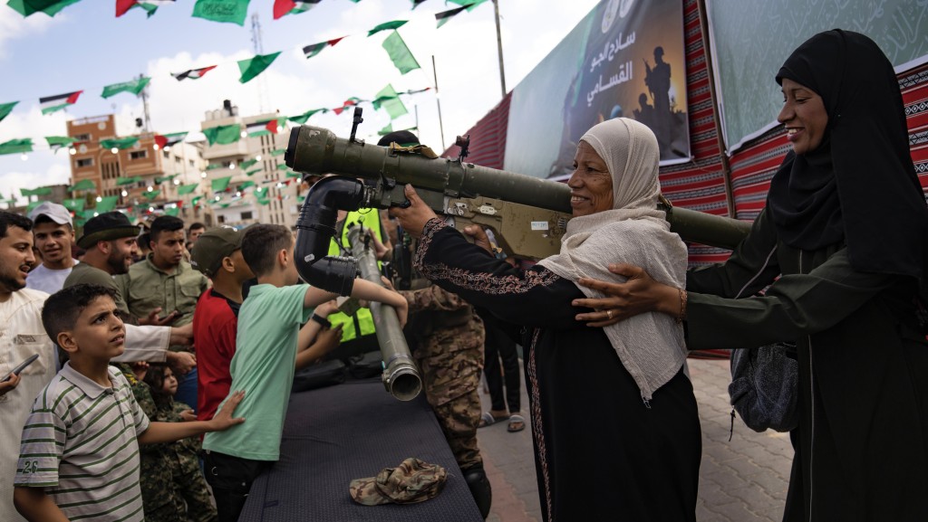 加沙巴勒斯坦婦女在努賽拉特難民營的哈馬斯「武器展」上試揸武器。 美聯社