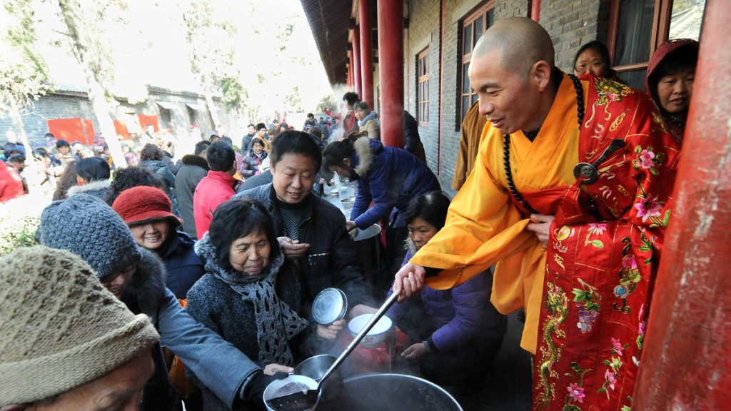 2011年,白馬寺方丈印樂法師在向市民施粥。新華社 2011年,白馬寺方丈印樂法師在向市民施粥。新華社