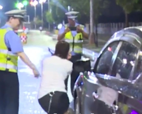 女子酒驾被查，交警拍照取证时，居然卖萌摆pose。（网图）