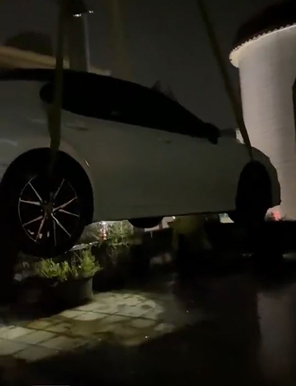 茂名有居民為免愛車被水淹壞，找「吊雞車」將汽車吊上天台避水。影片截圖