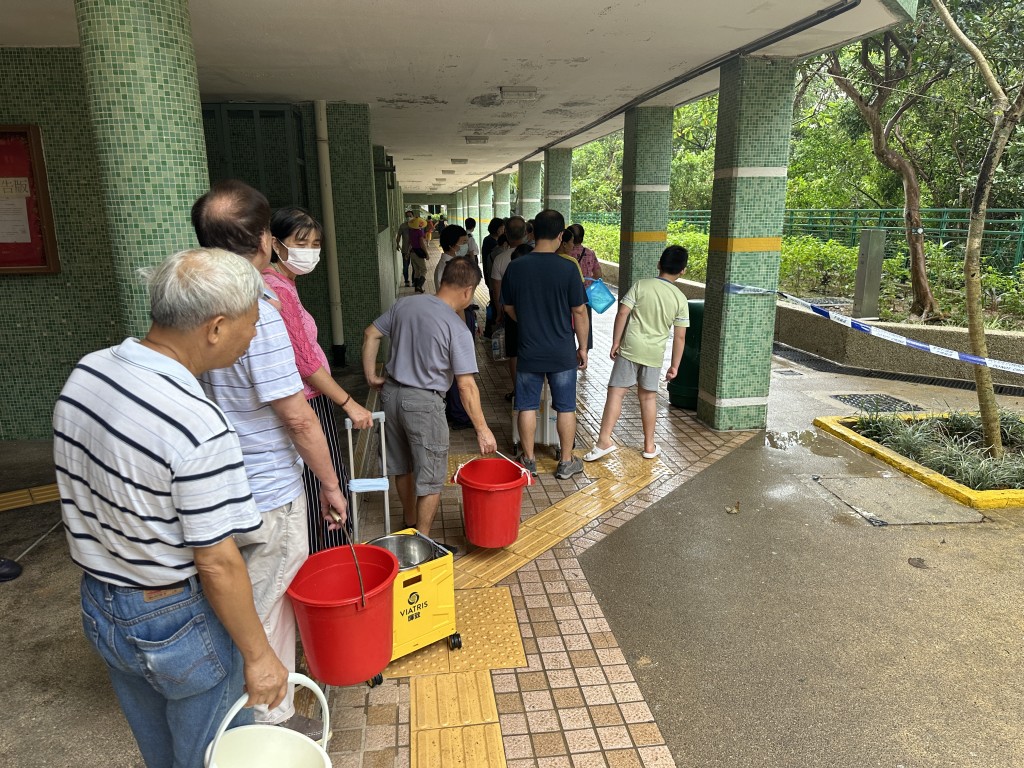 居民排队轮候取食水。梁国峰摄