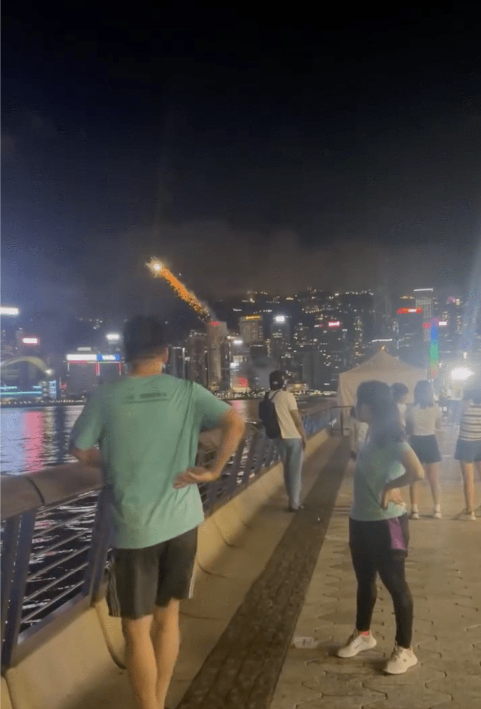 有人在海旁違法燃放煙花,吸引途人圍觀。網上片段截圖 有人在海旁違法燃放煙花,吸引途人圍觀。網上片段截圖