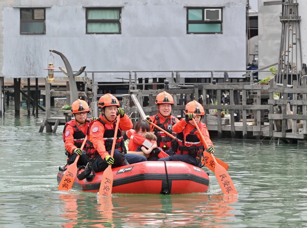 图中民众安全服务队队员以橡皮艇拯救模拟被困的居民。政府新闻处图片