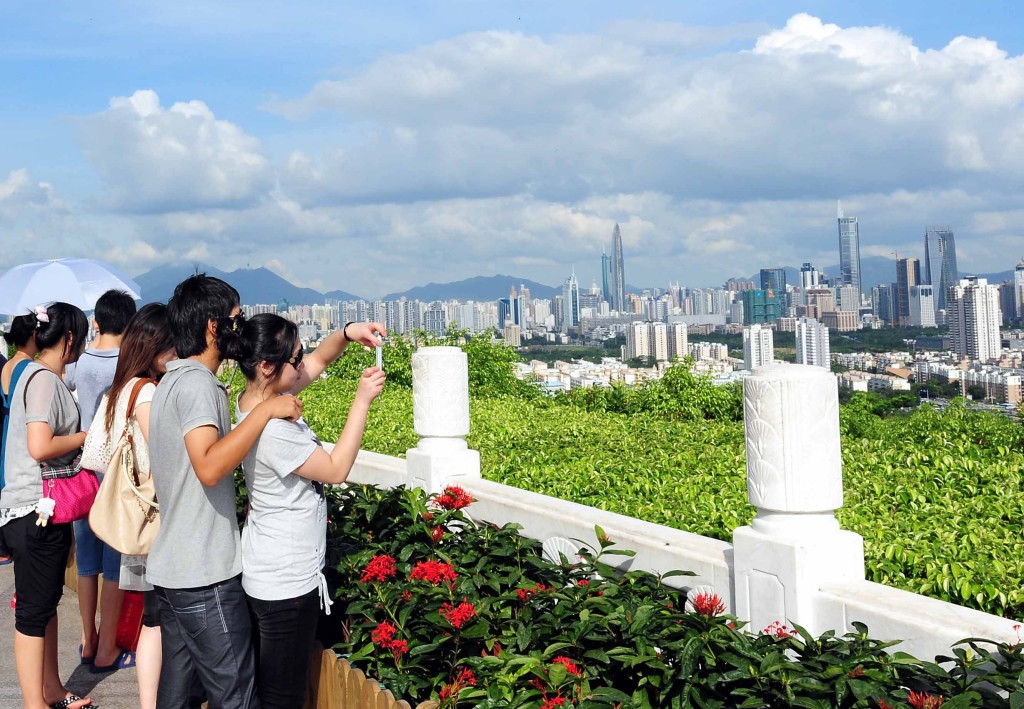 市民在深圳蓮花山公園的山頂廣場拍攝城市風光。