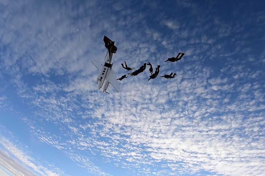 俯冲的飞机在跳伞队员身边掠过,十分惊险。互联网图片