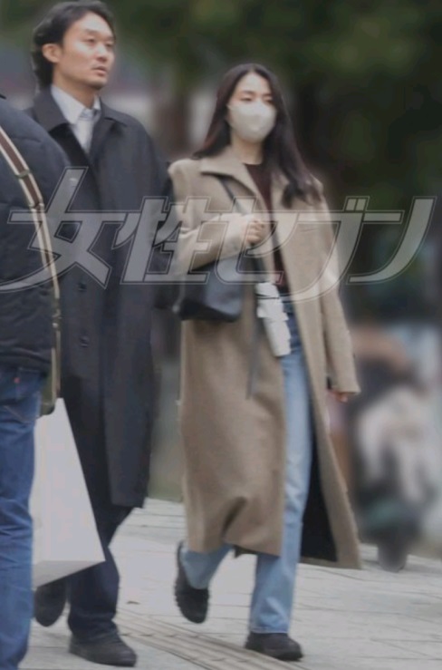 二人同穿上长大褛和牛仔裤，有点像在穿情侣装。