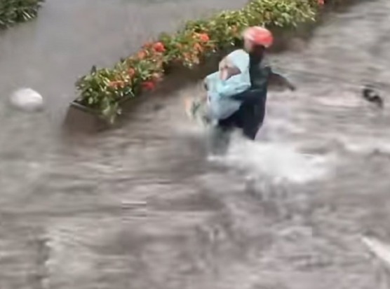 趙良金暴雨中抱起小孩。南方都市報