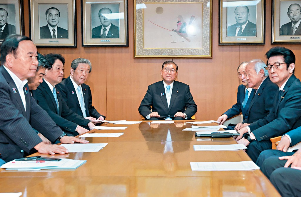 日本首相石破茂（中）周一在自民黨總部舉行高層會議。