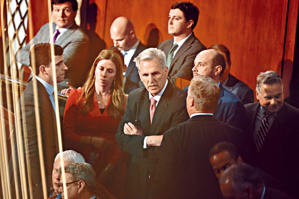 麦卡锡(中)周四在众议院议事厅与其他议员交谈。