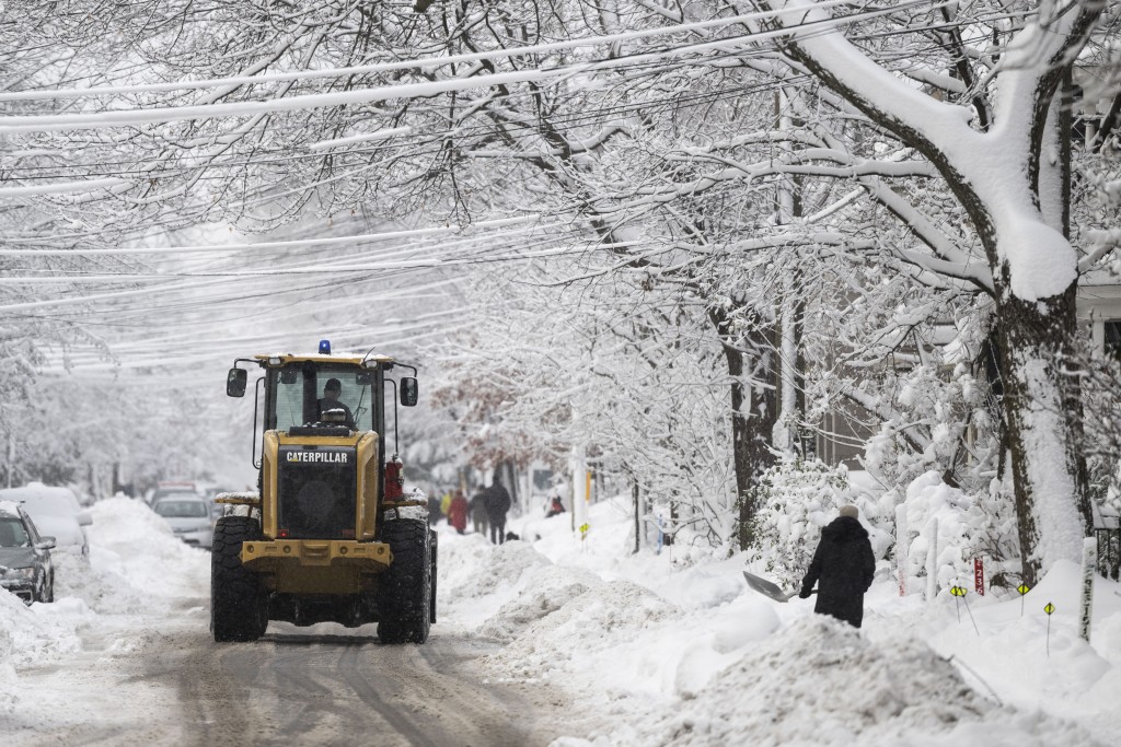 暴风雪过后，一辆扫雪机沿著渥太华的一条街道行驶。AP