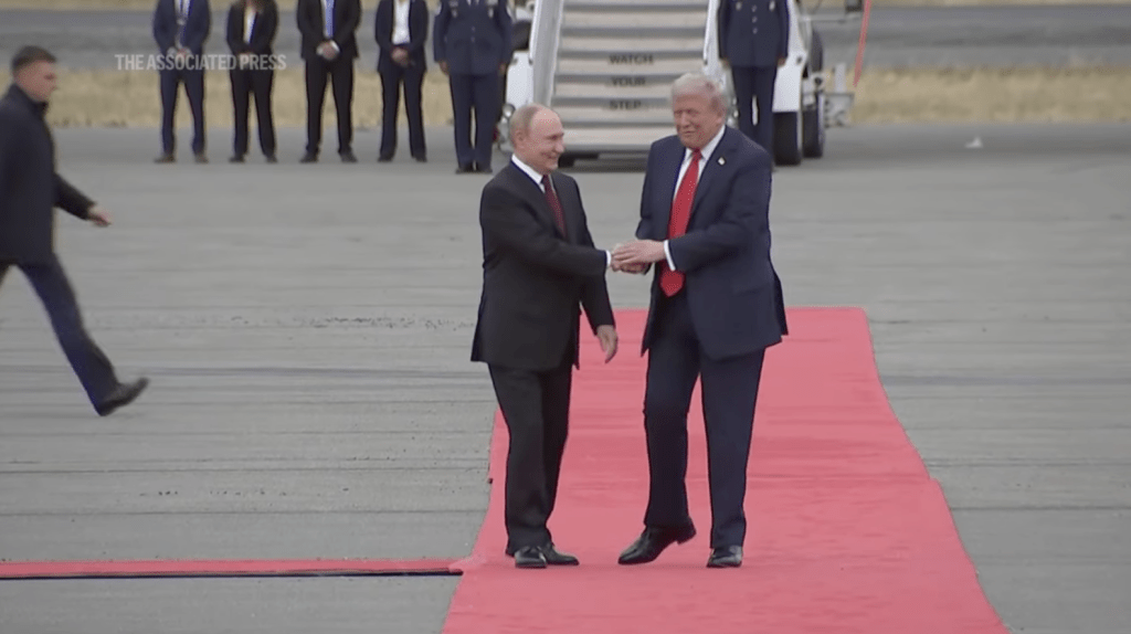 期間特朗普以雙手蓋覆普京右手,表現親切。美聯社畫面截圖 期間特朗普以雙手蓋覆普京右手,表現親切。美聯社畫面截圖