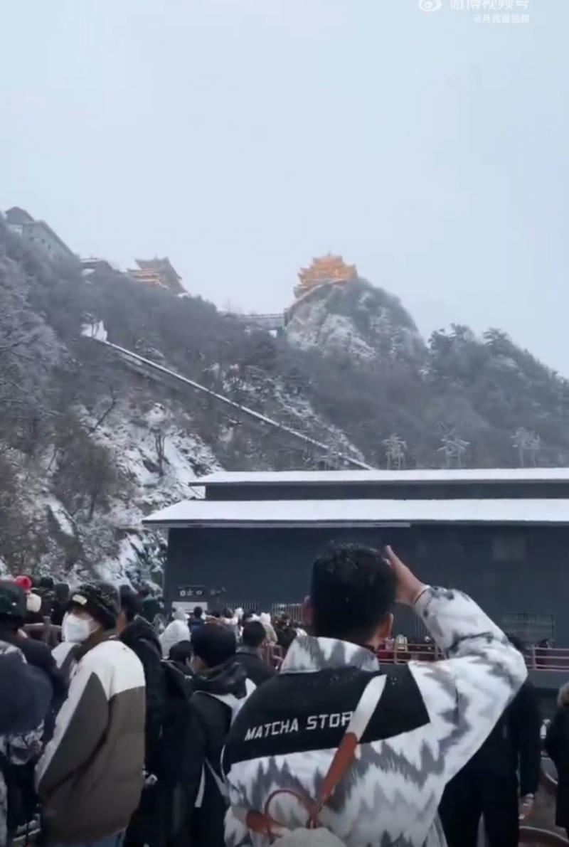 山顶上大雪纷飞游客冒雪攻顶。网图