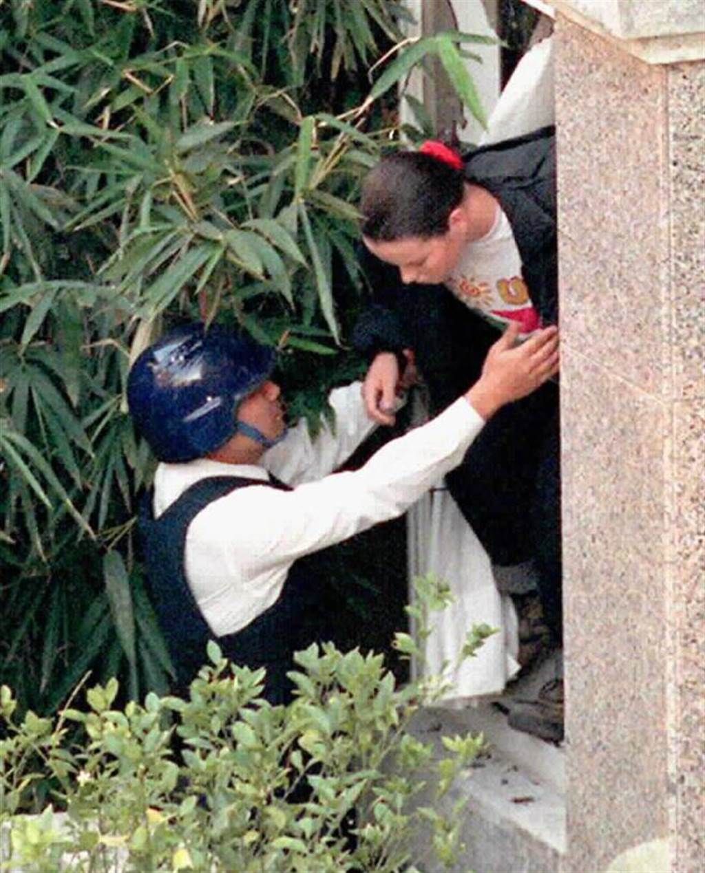 1997年南非武官挾持案，陳進興將南非武官卓懋祺女兒克麗絲汀(右)釋放時，時任刑大隊長侯友宜(左)從官邸窗戶將她接出來。 中時