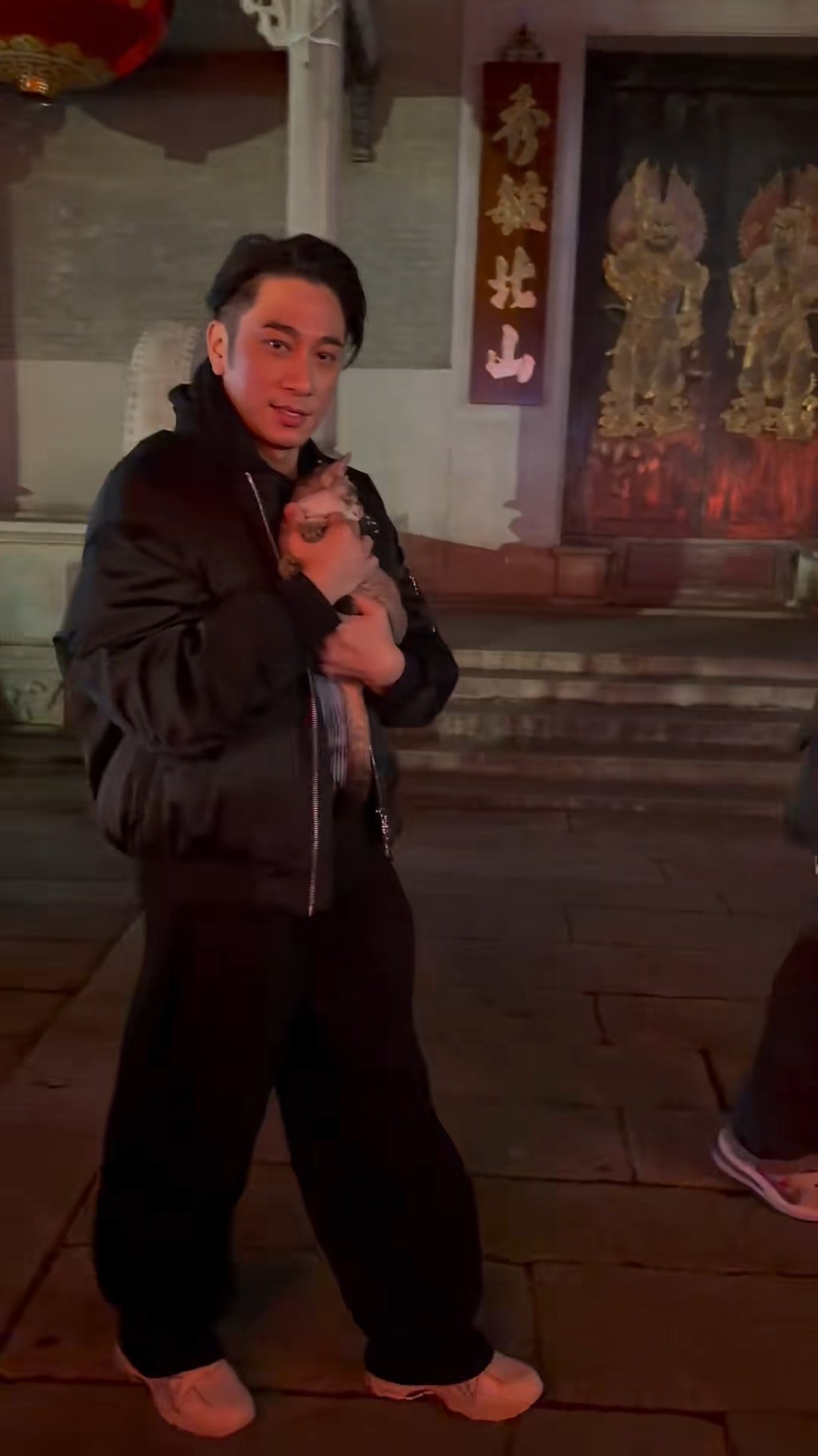 當時吳卓羲單手緊緊抱著貓咪。