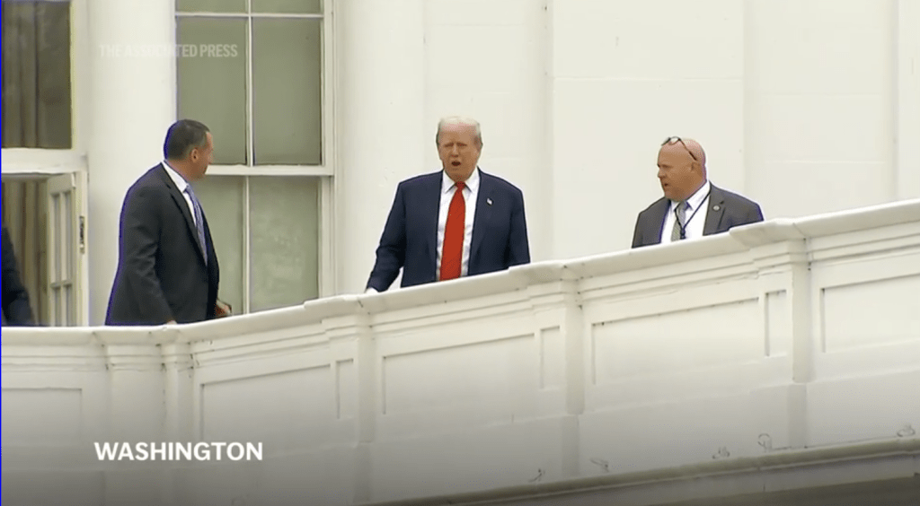 特朗普突然出现在白宫西翼的屋顶上。美联社 特朗普突然出现在白宫西翼的屋顶上。美联社