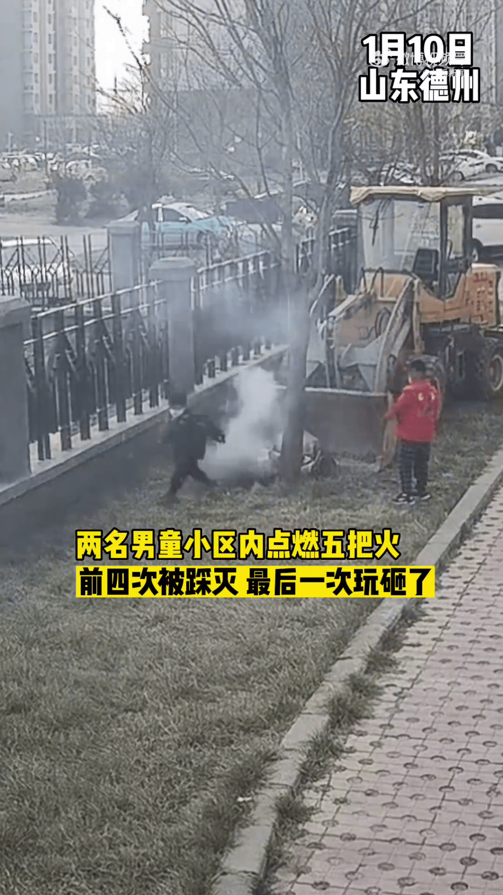 兩名小童在社區一輛鏟車後玩火，其中一名更在燃燒中的雜草上嘗試將火踩熄。