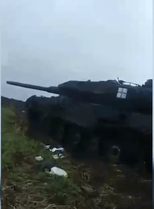俄羅斯士兵在幾輛裝甲車輛殘骸旁走動。