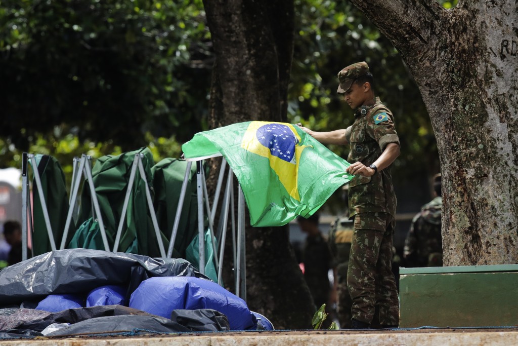 巴西前總統博索納羅的支持者離開軍隊總部外的營地後，留下大量國旗。AP
