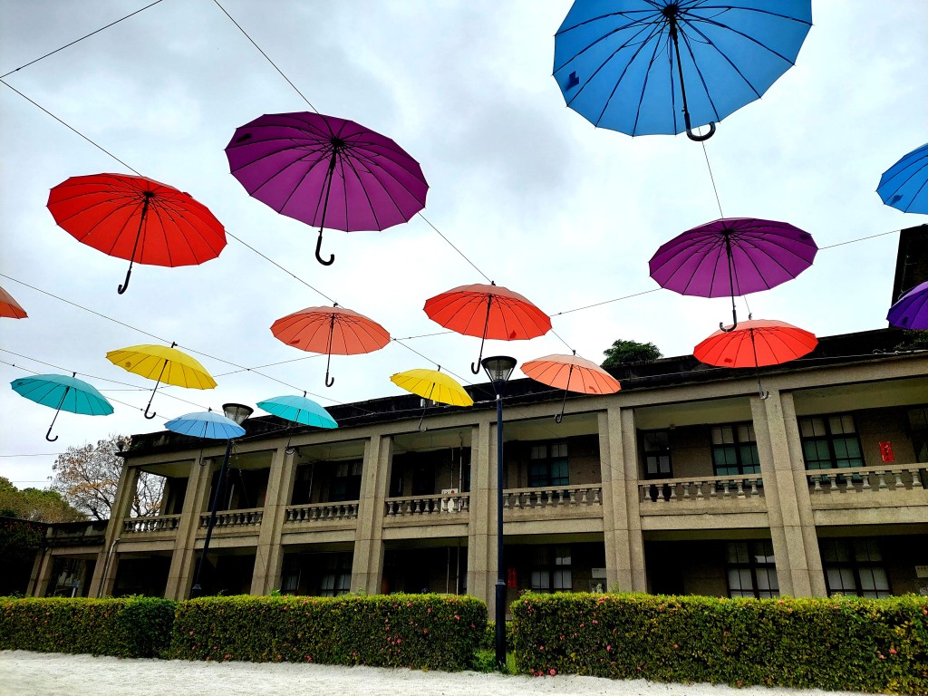 園內白沙區掛上五彩繽紛的「漂浮傘」裝置藝術，隨風搖曳，是遊人拍照打卡亮點。