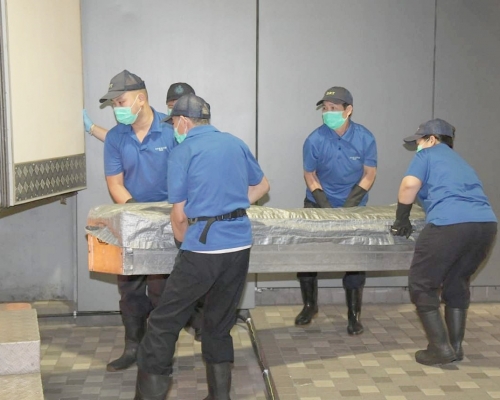 仵工將遺體移送至殮房。