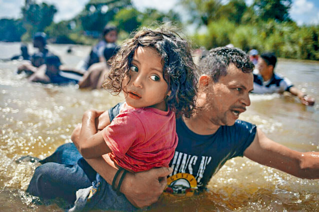 路透社获颁普立兹突发新闻摄影奖，图为偷渡往美国的洪都拉斯男子抱着女童渡河。