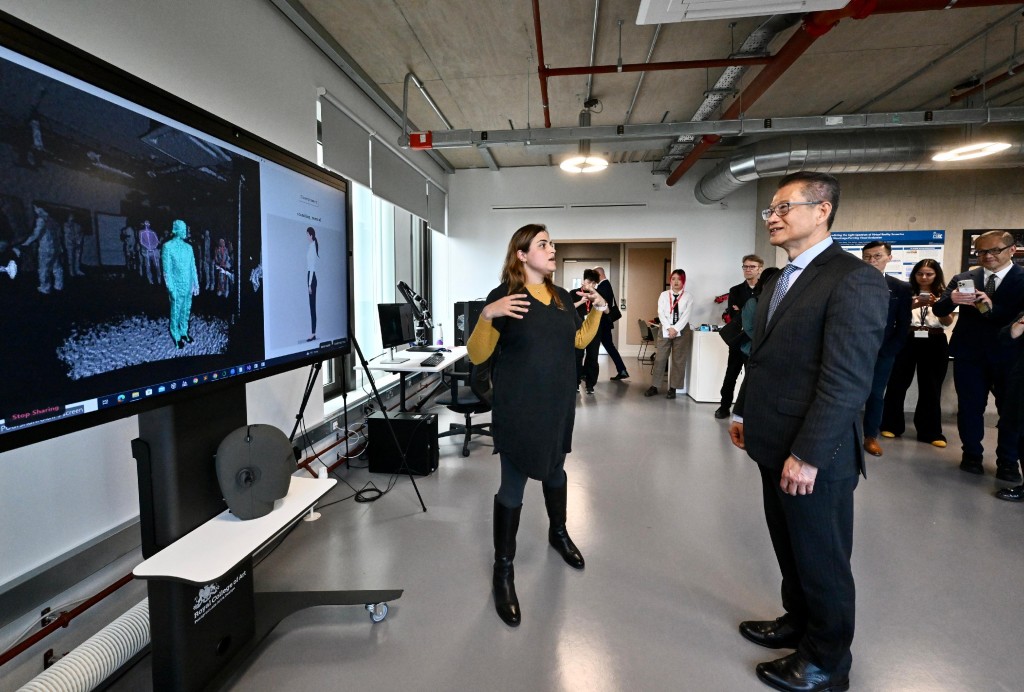 陳茂波（前排右）參觀「人工智能設計研究所」的應用研究項目的展示。政府新聞處
