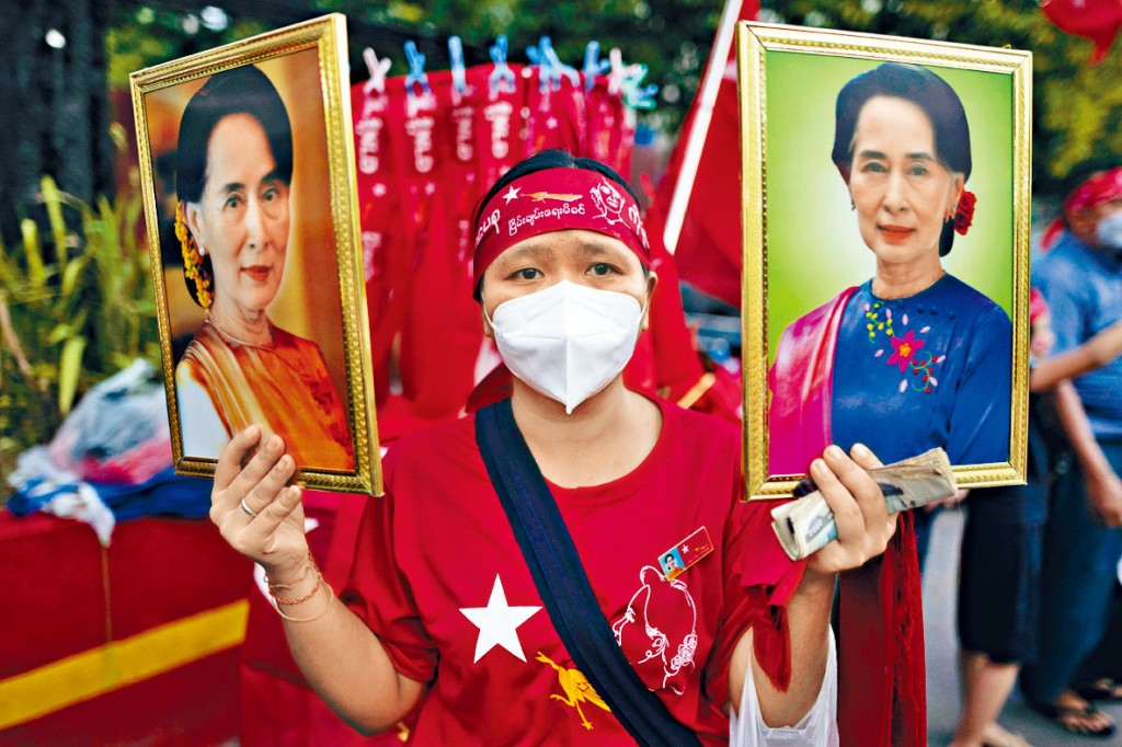 一名全民盟支持者周一持昂山素姬肖像，在仰光党总部庆祝。　
