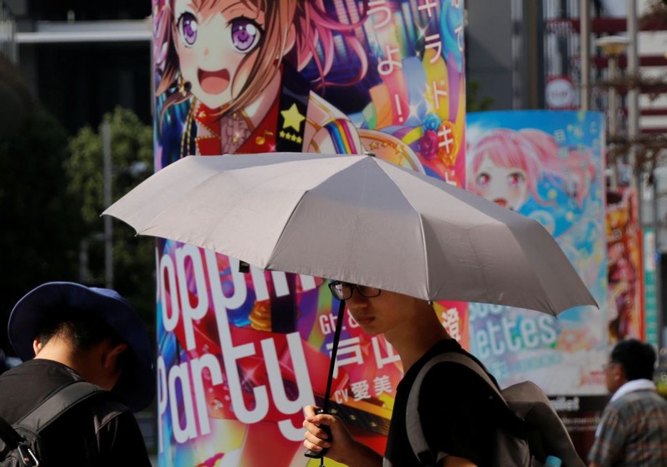 东京街头上市民张开太阳伞遮挡猛烈的阳光。路透社