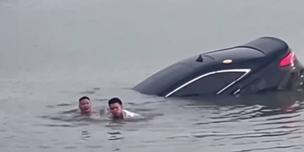 墮湖司機甦醒後，救人者將其從車窗拉出，車輛開始下沉。 央視截圖